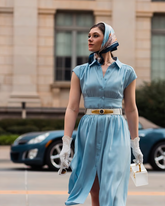 a lady wears a light blue flowy silk midi dress